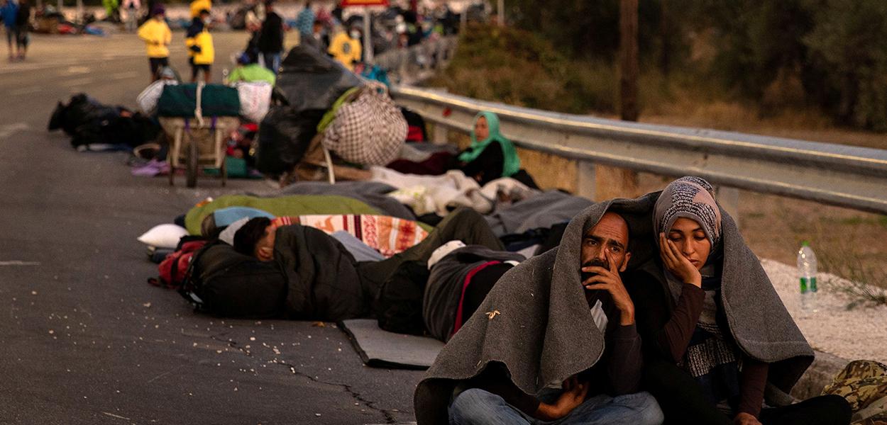 Imigrantes e refugiados se abrigam em acostamento após incêndio na ilha grega de Lesbos 10/09/2020