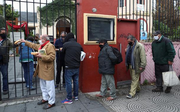 Pessoas fazem fila para obter ajuda de alimentação