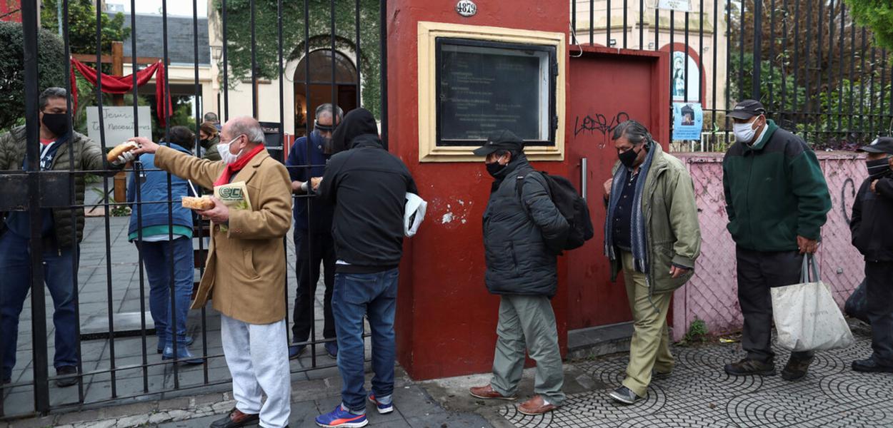 Pessoas fazem fila para obter ajuda de alimentação