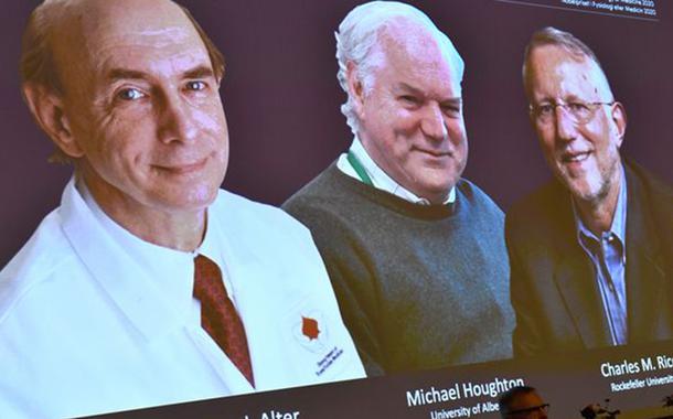 Fotos dos cientistas Harvey J. Alter, Michael Houghton e Charles M. Rice aparecem em tela durante anúncio de vencedores do Prêmio Nobel de Medicina em Estocolmo