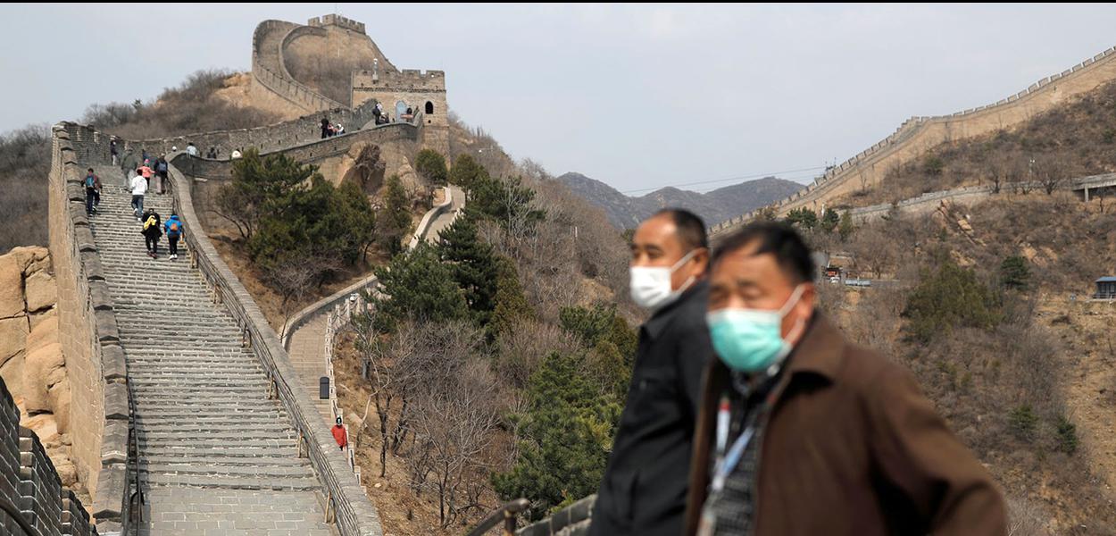 Mesmo de máscara, turistas já são vistos na Muralha da China.