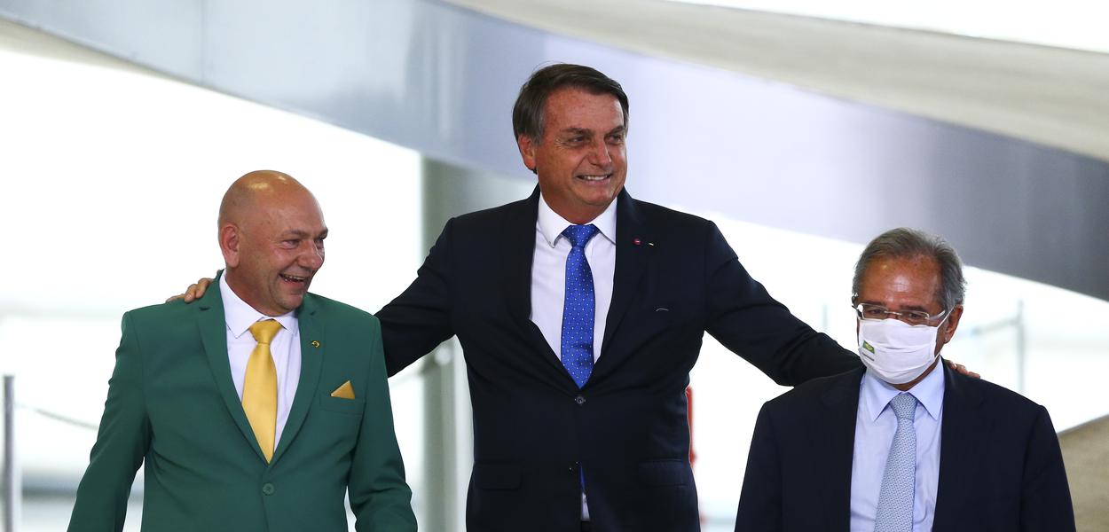 O empresário Luciano Hang, Jair Bolsonaro e o ministro da Economia, Paulo Guedes, durante o lançamento do programa Voo Simples, no Palácio do Planalto.