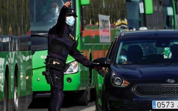 Policial espanhol conversa com pessoas em um carro em um dos postos de controle em meio a um lockdown parcial em Madri