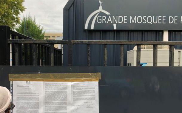 Mulher lê decreto na entrada da Grande Mesquista de Pantin