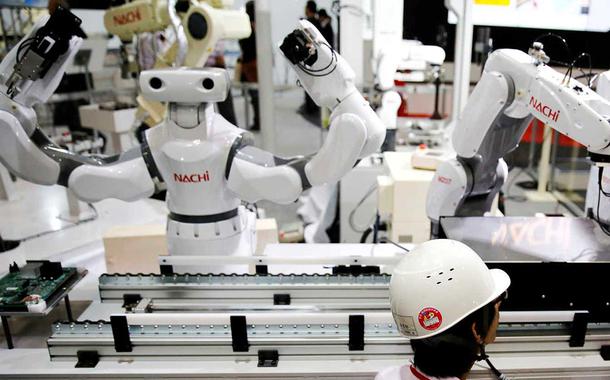 Staff program a robot arm by Nachi Robotic Systems at the International Robot Exhibition in Tokyo, Japan December 2, 2015.  REUTERS/Thomas Peter