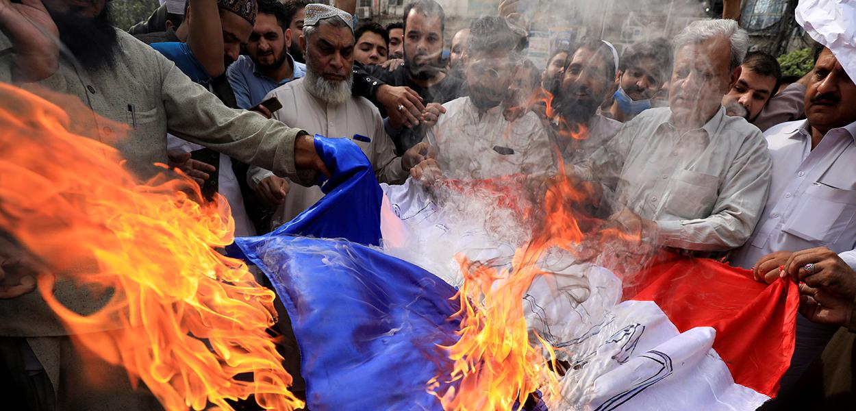 Em protesto contra presidente francês, Emmanuel Macron, manifestantes queimam bandeira fa França em Peshawar, Paquistão. 28/10/2020