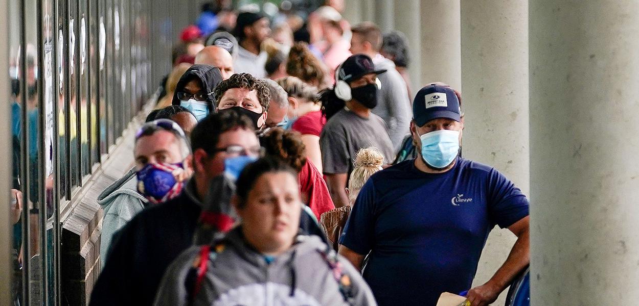 Centenas de pessoas na fila diante do Centro de Carreiras de Kentucky, esperando entrega de benefícios a desempregados.