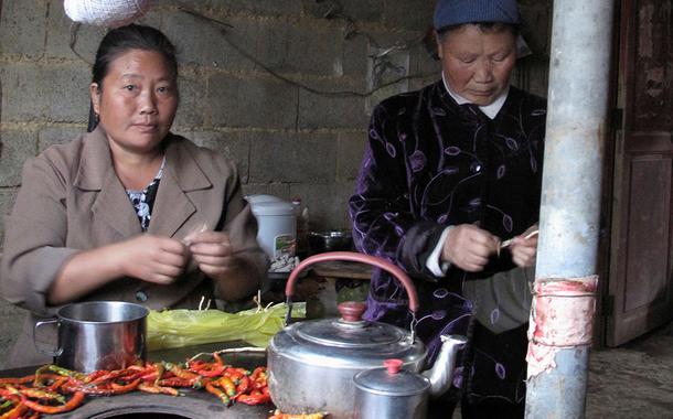 Yang Hechun, moradora da vila chinesa de Yangchang na empobrecida província de Guizhou prepara almoço em sua casa