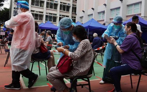 Profissionais atendem pacientes em centro comunitário de testes de detecção de coronavírus em Hong Kong