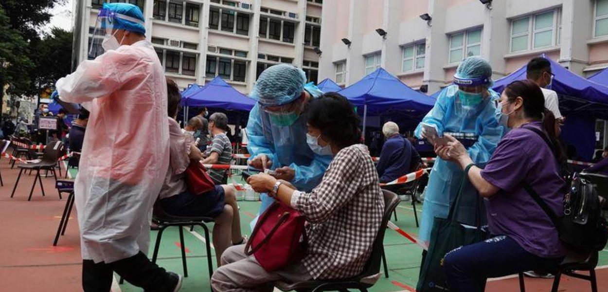 Profissionais atendem pacientes em centro comunitário de testes de detecção de coronavírus em Hong Kong