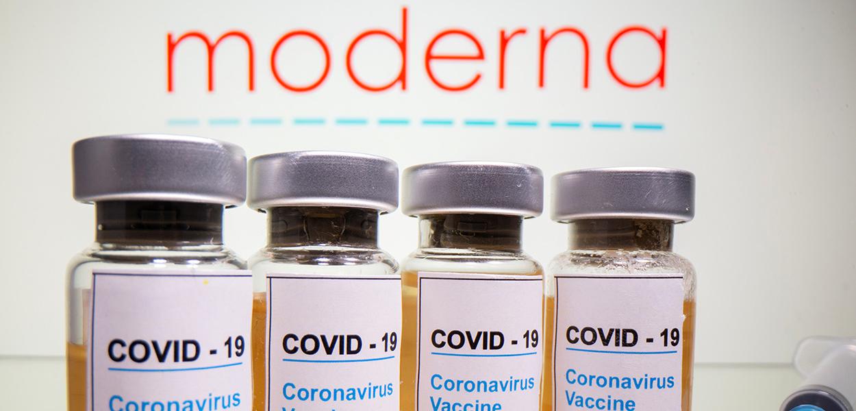 Frascos rotulados como de vacina contra Covid-19 em frente a logo da Moderna em foto de ilustração