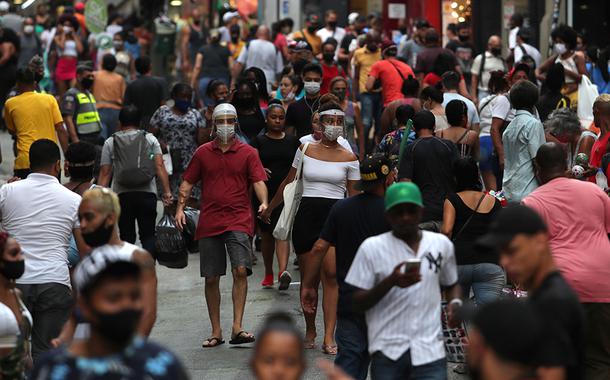 Pessoas caminham por rua de comércio popular no centro de São Paulo