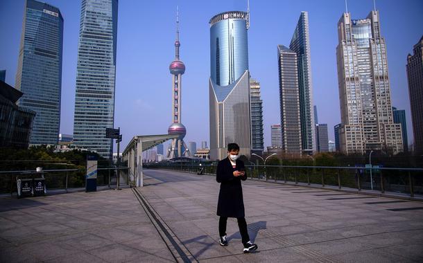 Homem anda na cidade de Xangai, na China