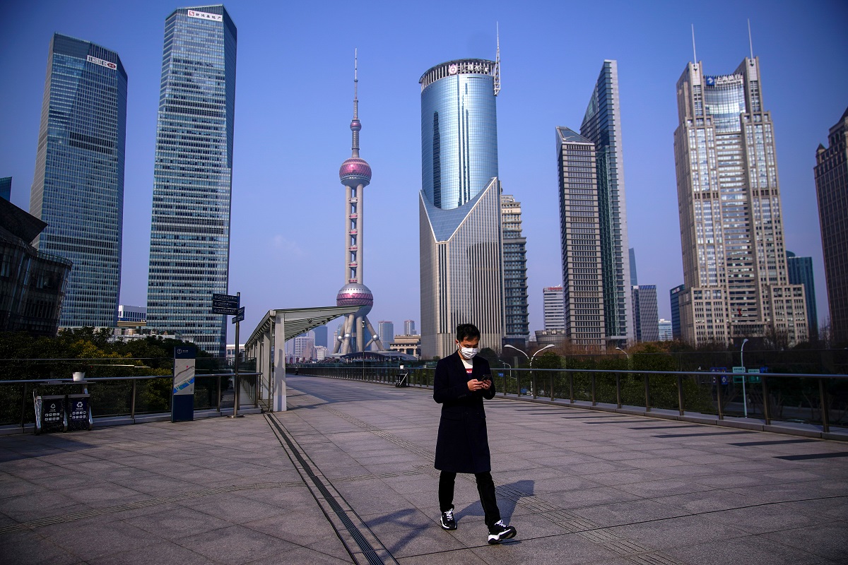 Homem anda na cidade de Xangai, na China