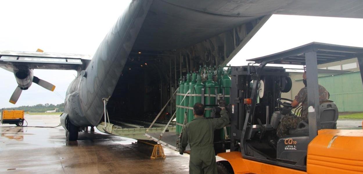 Homens das Forças Armadas carregam avião com cilindros de oxigênio para tratar a covid-19 em Manaus.