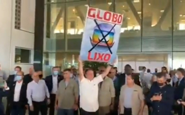 Bolsonaro ergue cartaz com mensagem "Globo lixo"