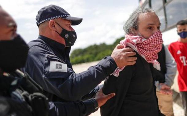 Manifestante é preso após fazer protesto contra Bolsonaro usando bandeira com suástica.