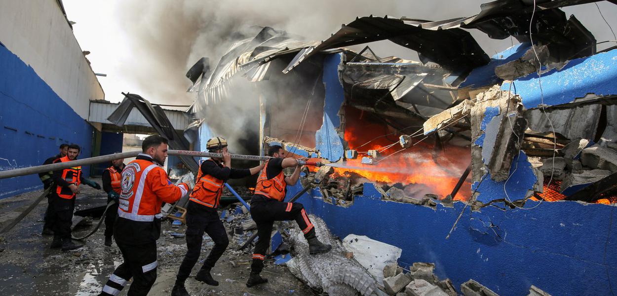 Bombeiros palestinos apagam chamas de fábrica atingida por míssil de Israel