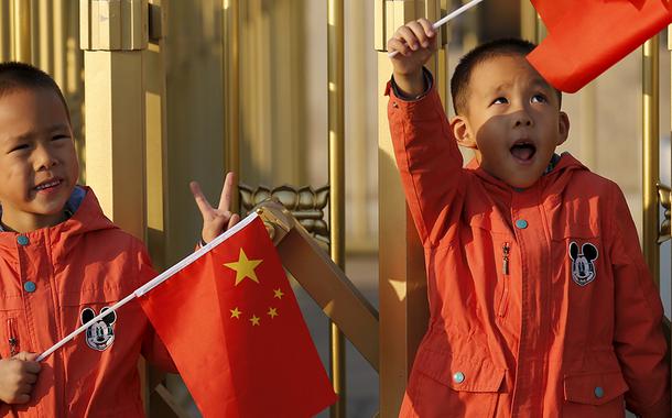 Gêmeos chineses com bandeira do país em praça de Pequimung-Hoon