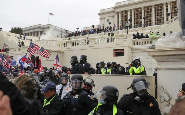 Policiais americanos montam guarda enquanto apoiadores do presidente norte-americano Donald Trumb protestam em frente ao Capitólio em Washington.