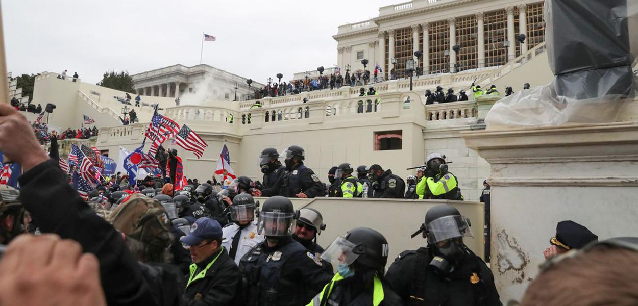 Policiais americanos montam guarda enquanto apoiadores do presidente norte-americano Donald Trumb protestam em frente ao Capitólio em Washington.