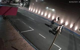 Dois homens armados conduzem uma fila com quatro reféns, alinhados lado a lado, por uma rua de Araçatuba.