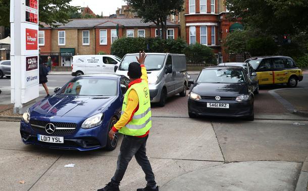 Funcionário de posto de combustível em Londres tenta organizar fila para abastecimento