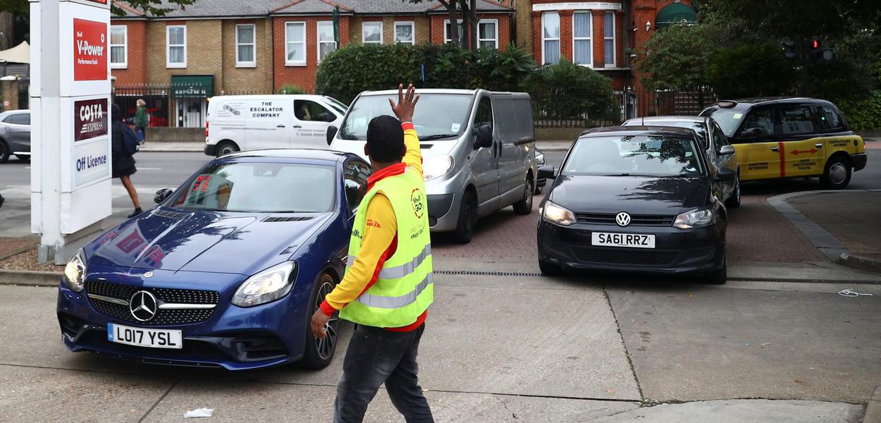 Funcionário de posto de combustível em Londres tenta organizar fila para abastecimento