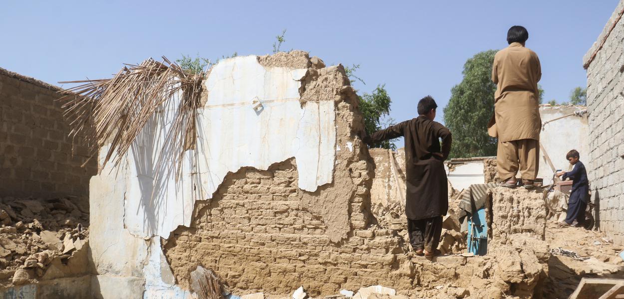 Moradores ao lado de escombros deixados por terremoto em Harnai, no Paquistão