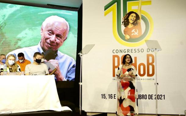 Luciana Santos, presidente do PCdoB fala no 15º Congresso. No painel, ao fundo, imagem de Haroldo Lima, dirigente do partido falecido em março último, homenageado no encontro