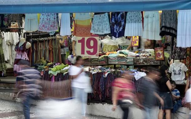 Pessoas passam em frente a loja em rua comercial de São Paulo