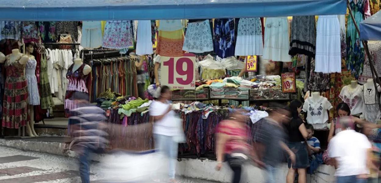 Pessoas passam em frente a loja em rua comercial de São Paulo