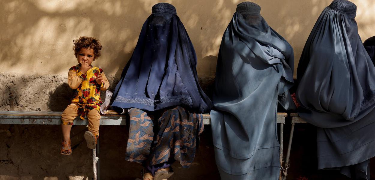 Menina afegã ao lado de três mulheres de burca em hospital de Cabul