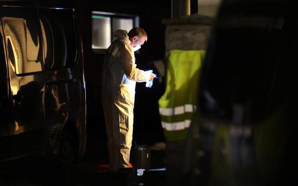 Perito forense coleta evidências na parte de fora da casa de uma família após polícia encontrar dois adultos e três crianças mortos em Berlim, na Alemanha