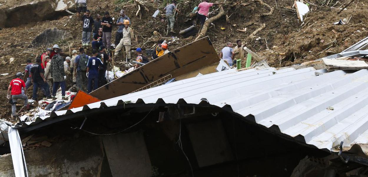 Bombeiros, moradores e voluntários trabalham no local do deslizamento no Morro da Oficina, após a chuva que castigou Petrópolis, na região serrana fluminense