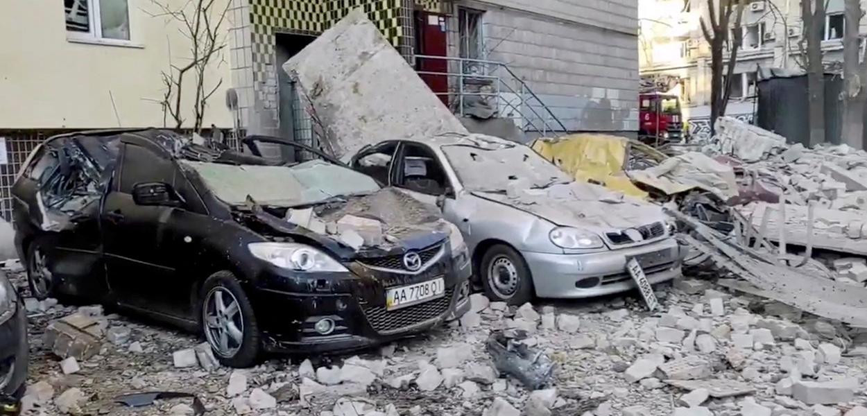 Veículos destruidos depois que prédio foi atingido por um bombardeio em Kiev