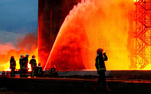 Rescuers work at a site of fuel storage facilities hit by cruise missiles, as Russia's attack on Ukraine continues, in Lviv, in this handout picture released March 27, 2022.  Press service of the State Emergency Service of Ukraine/Handout via REUTERS