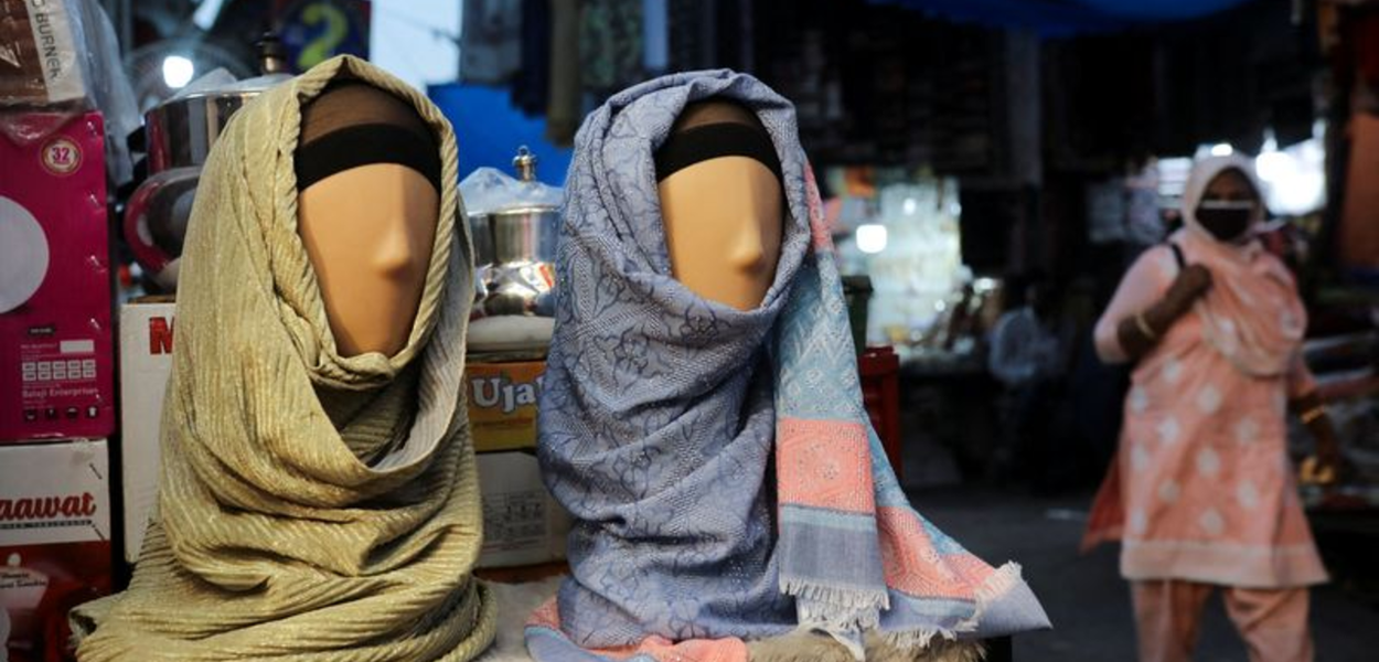 Mulher passa por manequins com hijabs em loja de Nova Délhi