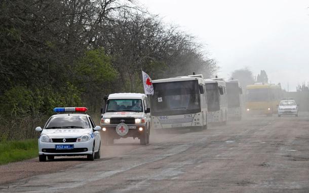 Um comboio de ônibus transportando civis de Mariupol, incluindo evacuados da siderúrgica Azovstal, é visto em uma estrada a caminho de Zaporizhzhia, durante o conflito Ucrânia-Rússia na região de Donetsk, Ucrânia, 2 de maio de 2022