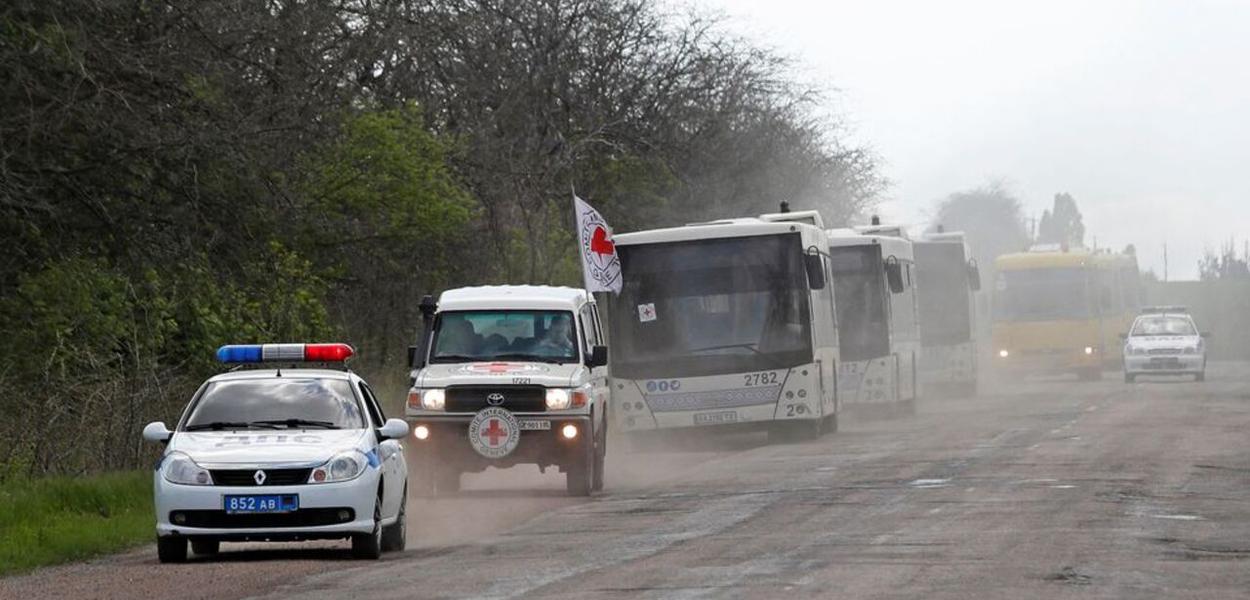 Um comboio de ônibus transportando civis de Mariupol, incluindo evacuados da siderúrgica Azovstal, é visto em uma estrada a caminho de Zaporizhzhia, durante o conflito Ucrânia-Rússia na região de Donetsk, Ucrânia, 2 de maio de 2022