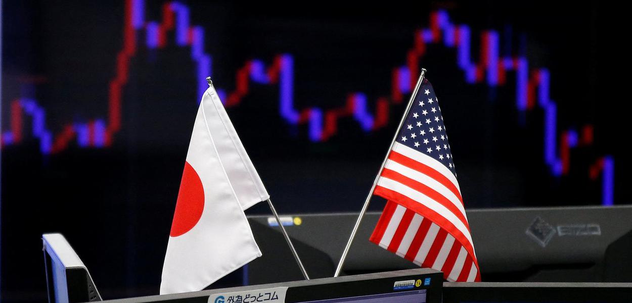 FILE PHOTO: National flags of Japan and the U.S. are seen in front of a monitor showing a graph of the Japanese yen's exchange rate against the U.S. dollar at a foreign exchange trading company in Tokyo, Japan, January 23, 2017.    REUTERS/Toru Hanai