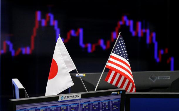 FILE PHOTO: National flags of Japan and the U.S. are seen in front of a monitor showing a graph of the Japanese yen's exchange rate against the U.S. dollar at a foreign exchange trading company in Tokyo, Japan, January 23, 2017.    REUTERS/Toru Hanai