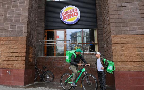 Entregadores de comida do lado de fora de uma unidade do Burger King em Moscou