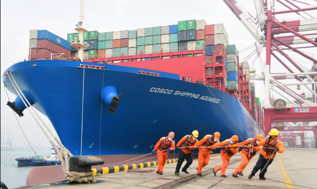 Trabalhadores vestem máscaras enquanto trabalham no porto em Qingdao, na China