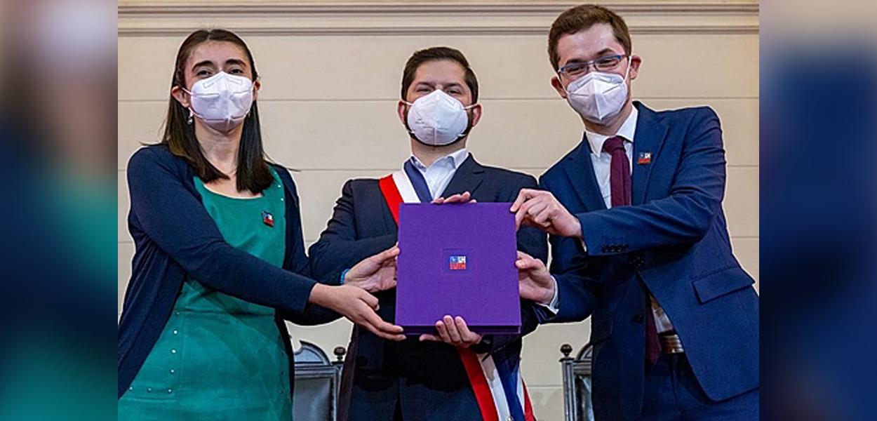 Presidenta da Convenção Constitucional, María Elisa Quinteros, e seu vice, Gaspar Domínguez, seguram proposta de nova constituição junto ao presidente chileno Gabriel Boric