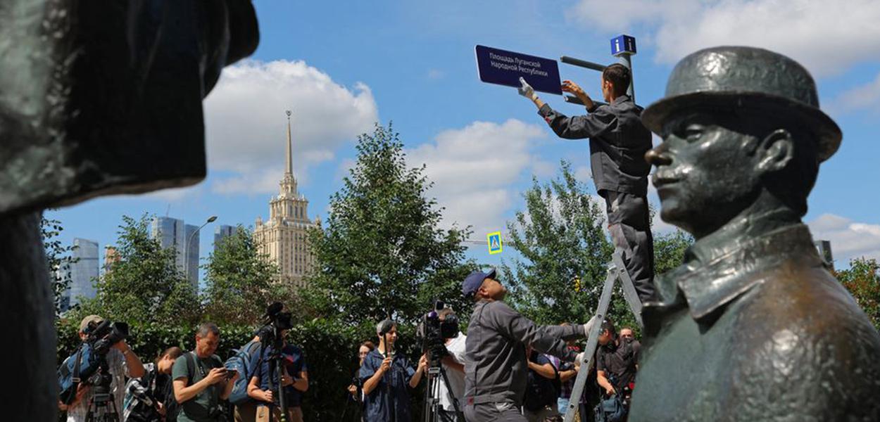Trabalhadores instalam uma placa de direção "Praça da República Popular de Luhansk" em frente à embaixada britânica em Moscou
