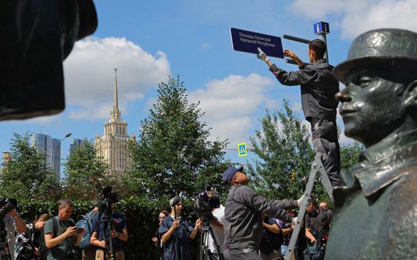 Trabalhadores instalam uma placa de direção "Praça da República Popular de Luhansk" em frente à embaixada britânica em Moscou