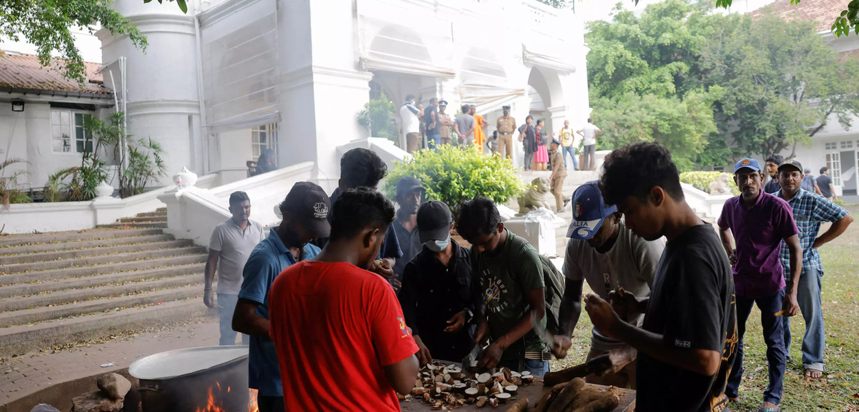 Pessoas cozinham no jardim da residência do primeiro-ministro, um dia após os manifestantes entrarem no prédio. Em Colombo, Sri Lanka, em 10 de julho de 2022
