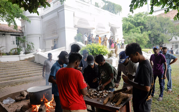 Pessoas cozinham no jardim da residência do primeiro-ministro, um dia após os manifestantes entrarem no prédio. Em Colombo, Sri Lanka, em 10 de julho de 2022