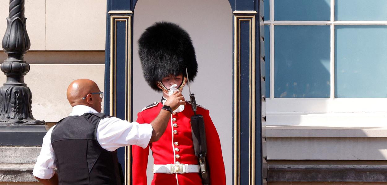 Membro da Guarda da Rainha recebe água do lado de fora do Palácio de Buckingham